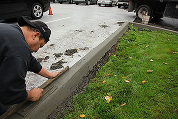 Workers installing hand-formed concrete curb, AC Moate Industries